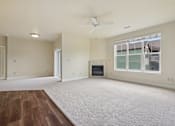 Thumbnail 22 of 42 - A spacious living room with a fireplace and a ceiling fan.