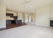 Thumbnail 21 of 42 - A spacious living room with a fireplace and a ceiling fan.