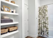 Thumbnail 33 of 49 - a bathroom with white shelves and a shower curtain with a green and white tree print