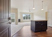 Thumbnail 30 of 42 - A modern kitchen with dark wood floors and a large island.