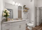 Thumbnail 12 of 46 - a bathroom with white walls and a white toilet next to a white sink with a vase