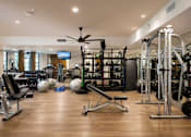 Thumbnail 4 of 40 - A spacious gym with a variety of equipment and a television.