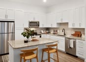 Thumbnail 2 of 46 - a kitchen with a large island with two stools in front of it