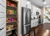 Thumbnail 72 of 94 - a kitchen with white cabinets and a stainless steel refrigerator