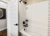 Thumbnail 86 of 94 - a bathroom with a bath tub and a white door