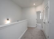 Thumbnail 12 of 27 - a bedroom with a medium sized bed and a doorway into a room
