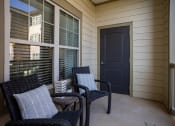 Thumbnail 13 of 30 - the front porch of a home with two chairs and a black door