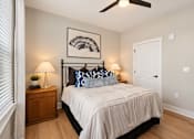Thumbnail 6 of 29 - A bedroom with a bed, two lamps, and a ceiling fan.