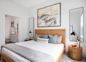 Thumbnail 11 of 46 - Pet-Friendly Apartments in Norcross, GA - The Darnell - Bedroom with Bed, Nightstands, Lamps, Wall Decor, and Attached Bathroom