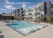 Thumbnail 18 of 40 - a swimming pool in front of an apartment building
