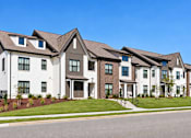 Thumbnail 29 of 29 - A row of modern houses with white and brown exteriors.