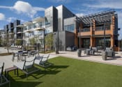 Thumbnail 19 of 40 - a rendering of a building with lawn chairs and tables
