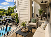 Thumbnail 5 of 40 - A balcony with a table and chairs overlooking a pool.