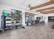 Thumbnail 22 of 46 - a spacious fitness room with hardwood floors and white walls