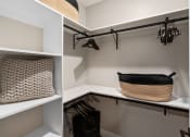 Thumbnail 84 of 94 - a walk in closet with shelves and a basket on a shelf