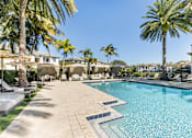 Thumbnail 37 of 53 - A large swimming pool surrounded by palm trees and lounge chairs.