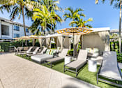 Thumbnail 38 of 53 - A patio with a white umbrella and a striped awning.