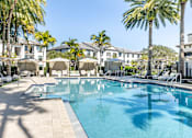 Thumbnail 39 of 53 - A large swimming pool surrounded by palm trees and lounge chairs.