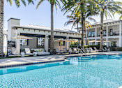 Thumbnail 40 of 53 - A pool surrounded by palm trees and lounge chairs.
