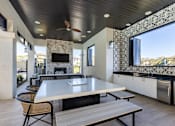 Thumbnail 43 of 53 - A modern outdoor kitchen with a table and chairs.