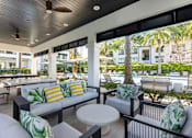 Thumbnail 42 of 53 - A patio with a white couch and a table with a plant on it.