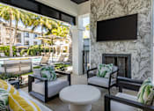 Thumbnail 41 of 53 - A patio with a white table and chairs with green cushions.