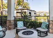 Thumbnail 49 of 53 - A patio with a fire pit and chairs.