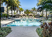 Thumbnail 3 of 53 - A pool surrounded by palm trees and plants.