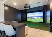 Thumbnail 19 of 53 - A room with a long table and chairs and a screen showing a golf course.