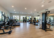 Thumbnail 15 of 53 - A gym with treadmills, elliptical machines, and other exercise equipment.