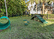Thumbnail 53 of 53 - A playground with a green slide and a green roundabout.