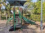 Thumbnail 52 of 53 - A playground with a green slide and a black and green structure.