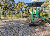 Thumbnail 51 of 53 - A playground with a green slide and a black and green swing set.