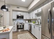 Thumbnail 21 of 53 - A modern kitchen with stainless steel appliances and white cabinetry.