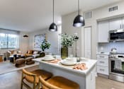 Thumbnail 20 of 53 - A modern kitchen with a dining area and a living room.