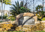 Thumbnail 1 of 53 - A sign that says "The Preserve Cypress Hammock 5201" is in front of a stone wall and palm trees.