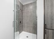 Thumbnail 30 of 34 - A modern bathroom with a walk-in shower.