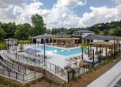 Thumbnail 24 of 46 - 3-Bedroom Apartments in Norcross, GA - The Darnell - Gated Swimming Pool with Spacious Sunbathing Areas, Lounge Seats, Umbrellas, Tables and Chairs, Firepit, and Pergolas