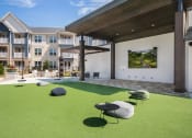 Thumbnail 38 of 49 - an outdoor lounge area with astroturf and stools