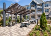 Thumbnail 39 of 49 - a patio with tables and chairs at the enclave at woodbridge apartments in sugar land, tx