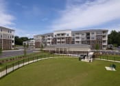 Thumbnail 43 of 46 - a building with a lawn in the foreground and a parking lot in the background