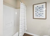 Thumbnail 12 of 38 - A white shower curtain hanging in a bathroom.