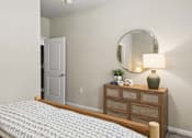 Thumbnail 14 of 38 - A bedroom with a bed, dresser, mirror, and lamp.
