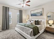 Thumbnail 9 of 38 - A bedroom with a large bed and a ceiling fan.
