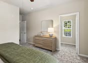 Thumbnail 10 of 38 - A bedroom with a bed, dresser, and mirror.