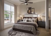 Thumbnail 11 of 16 - A bedroom with a large bed and a ceiling fan.