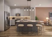 Thumbnail 9 of 16 - A modern kitchen with a refrigerator, stove, and bar stools.