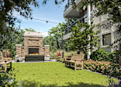 Thumbnail 8 of 16 - A backyard with a fireplace and a bench.