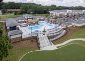 Thumbnail 44 of 46 - an aerial view of a resort style pool with a clubhouse in the background