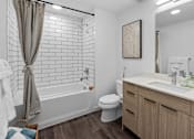 Thumbnail 19 of 45 - A white bathroom with a toilet, sink, and bathtub.